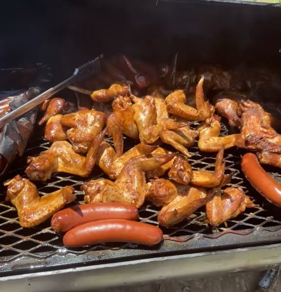 Wings and sausage cooking over the coals on the Iron Barrel Eats smoker