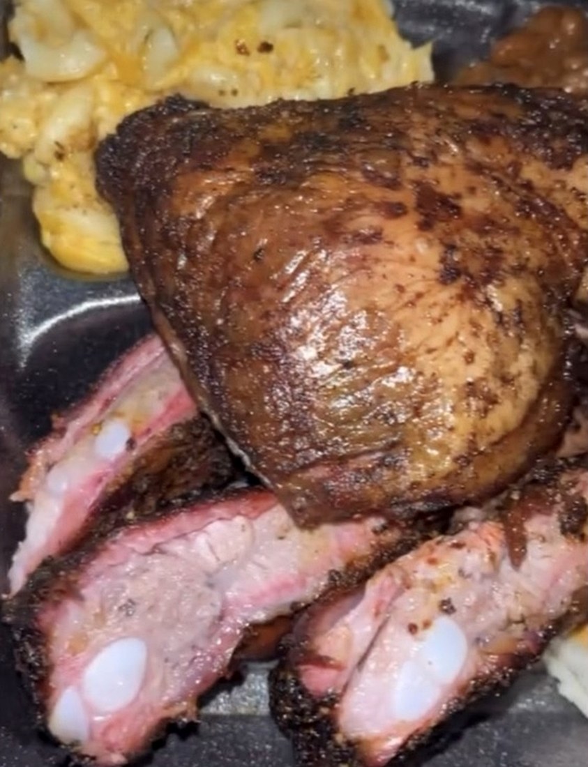 Smoked chicken quarter, sliced ribs and house-made mac and cheese on a tray