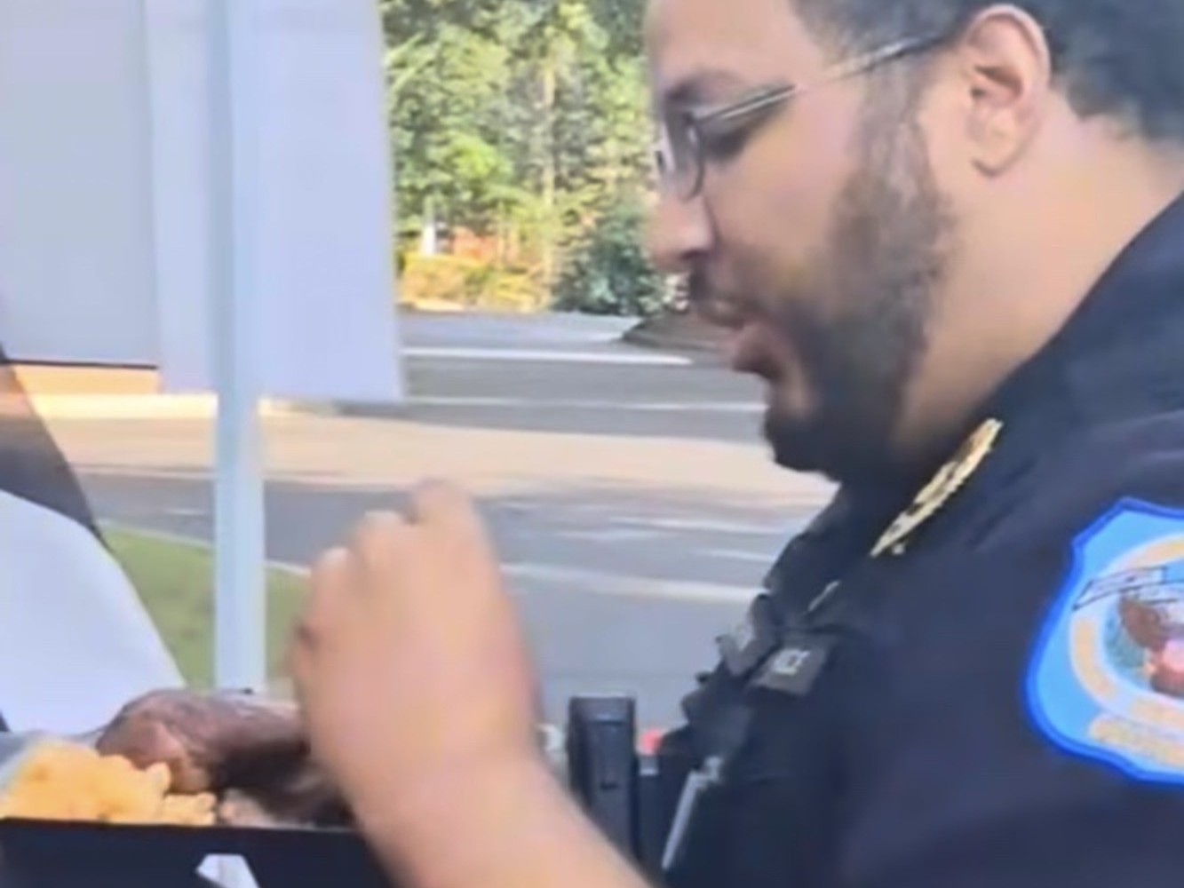 On-site security officer eating a plate of smoked chicken and mac and cheese at a resident event